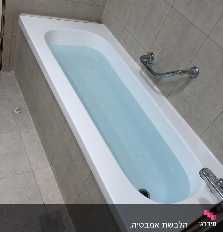 אמבטיה עם מים, קיר מחופה אריחים, ידית אחיזה